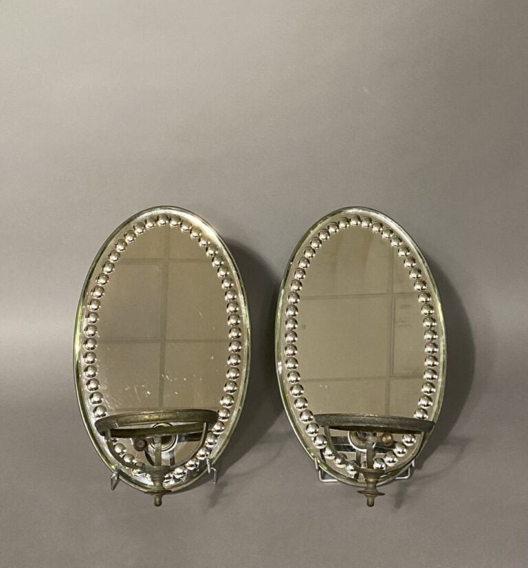 Paire d'appliques miroirs ovales à pastilles ornés d'un présentoir rond en méta…
