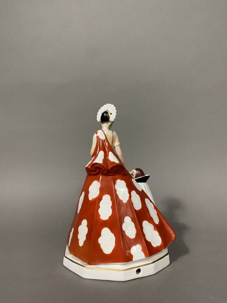 Sujet en porcelaine émaillée polychrome figurant une jeune femme debout en cost…