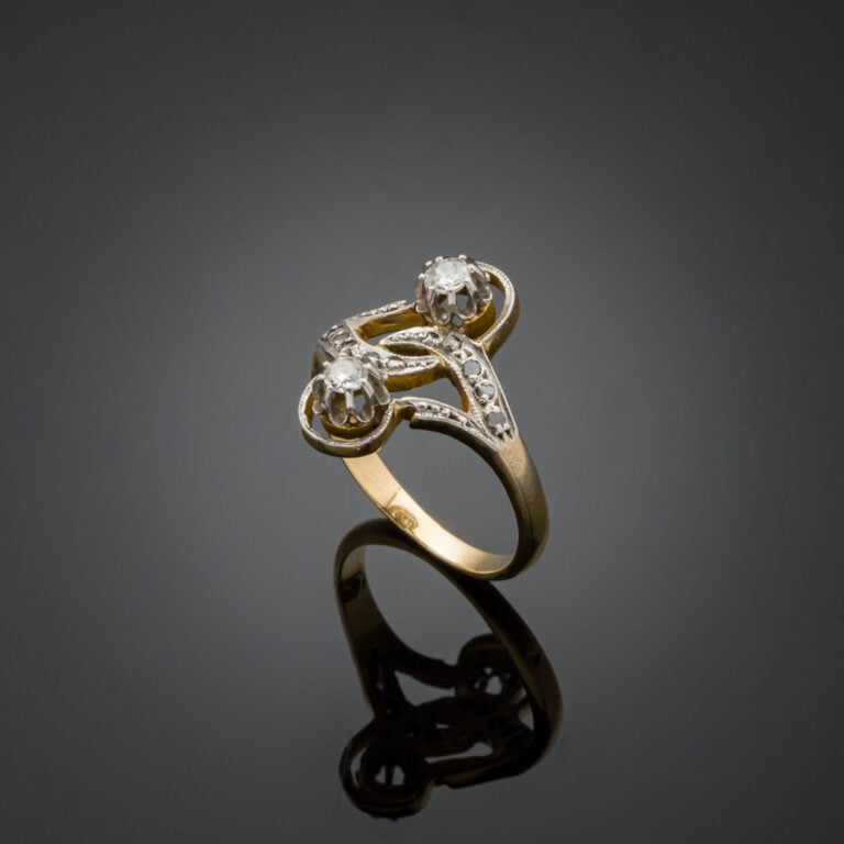 BAGUE "sinueuse" en or jaune et or gris (750‰) ajouré, serti de diamants taille…