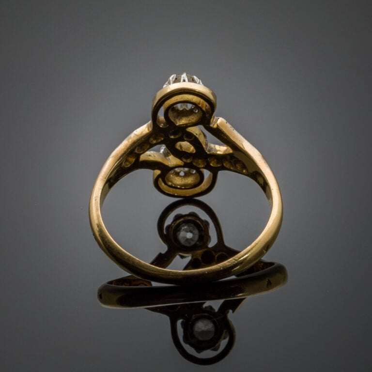 BAGUE "sinueuse" en or jaune et or gris (750‰) ajouré, serti de diamants taille…