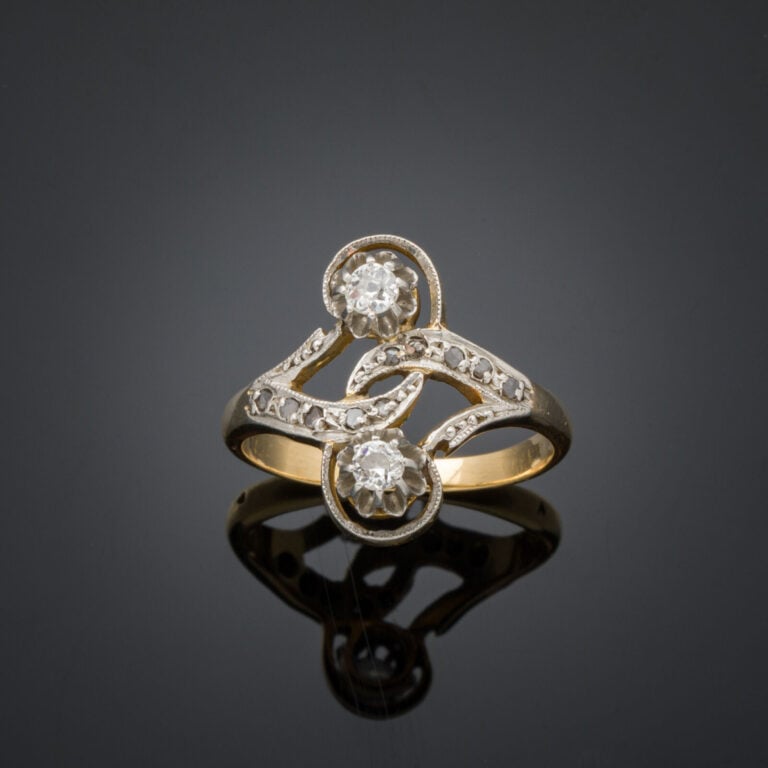 BAGUE "sinueuse" en or jaune et or gris (750‰) ajouré, serti de diamants taille…