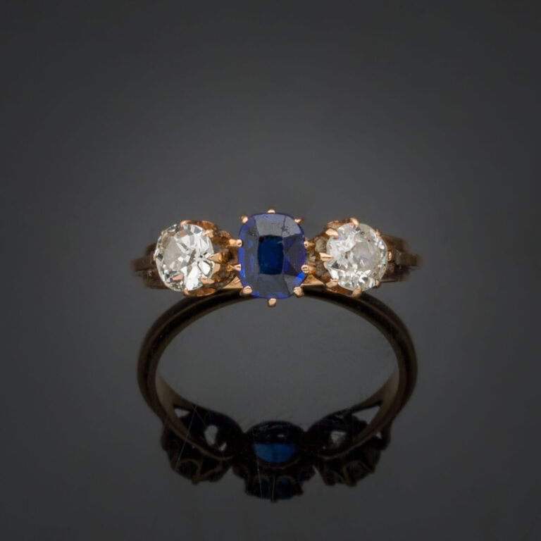 BAGUE "trilogie" en or rose (750‰) serti d'un saphir taille coussin, épaulé de…