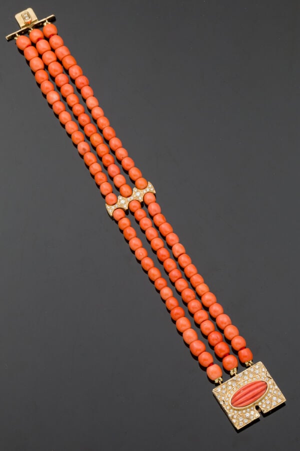 BRACELET en or jaune (585‰) 14 carats, composé de trois rangs de perles de cora…