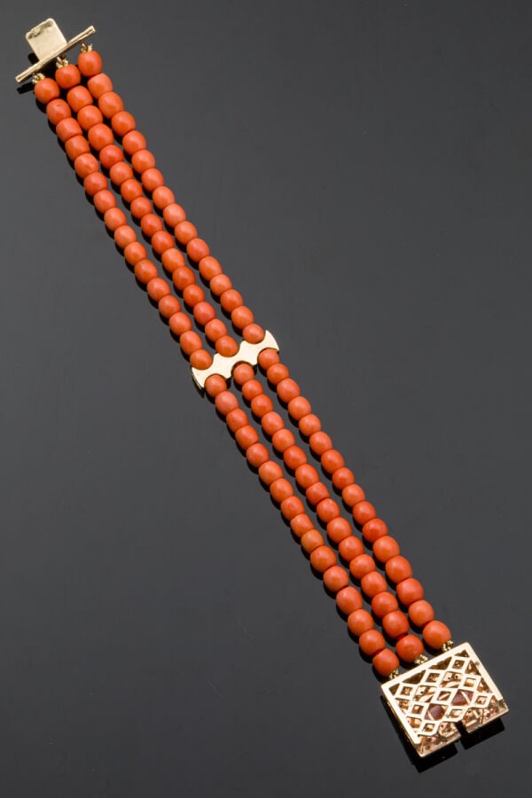 BRACELET en or jaune (585‰) 14 carats, composé de trois rangs de perles de cora…