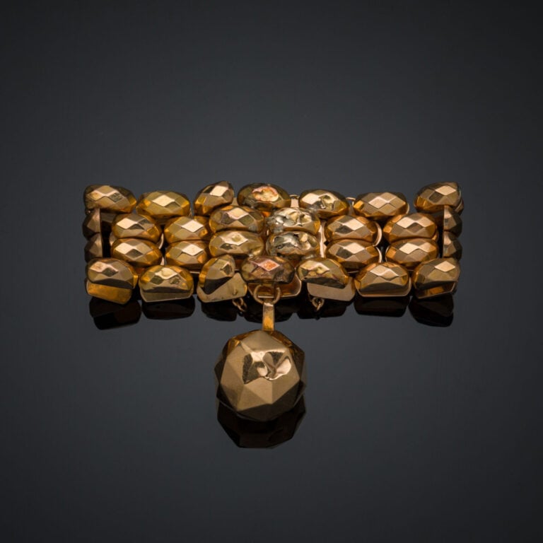 BRACELET manchette en or jaune (750‰) composé de quatre rangs de maillons facet…