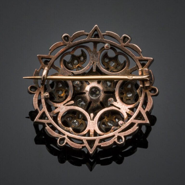 BROCHE circulaire "rosace" en or rose (750‰) et argent (min. 800‰) ajourés, ser…