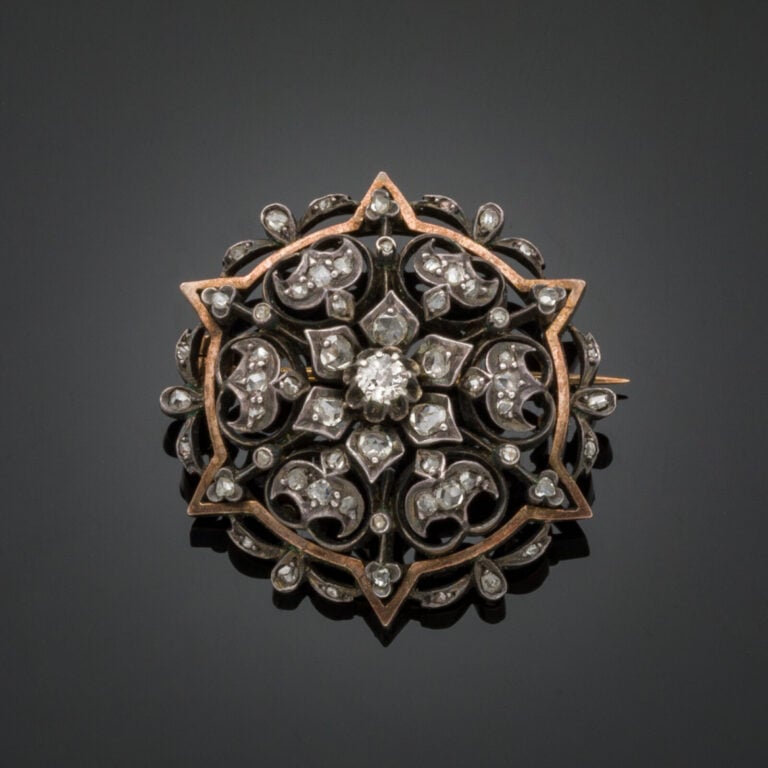 BROCHE circulaire "rosace" en or rose (750‰) et argent (min. 800‰) ajourés, ser…