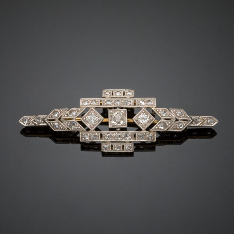 BROCHE géométrique en platine (min. 800‰) et or jaune (750‰) ajouré, serti de d…