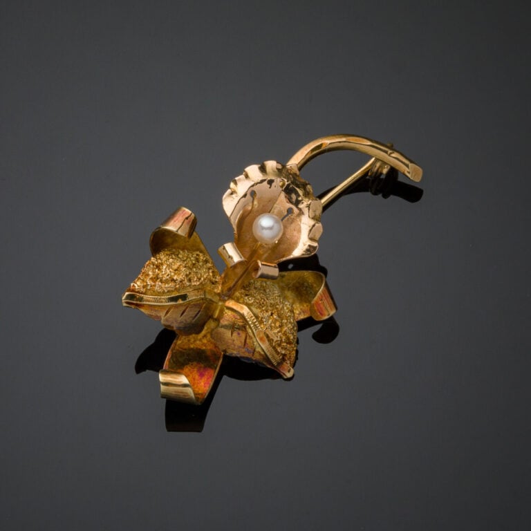 BROCHE "rose" en or jaune (750‰) ciselé et guilloché. Chaînette et épingle de s…