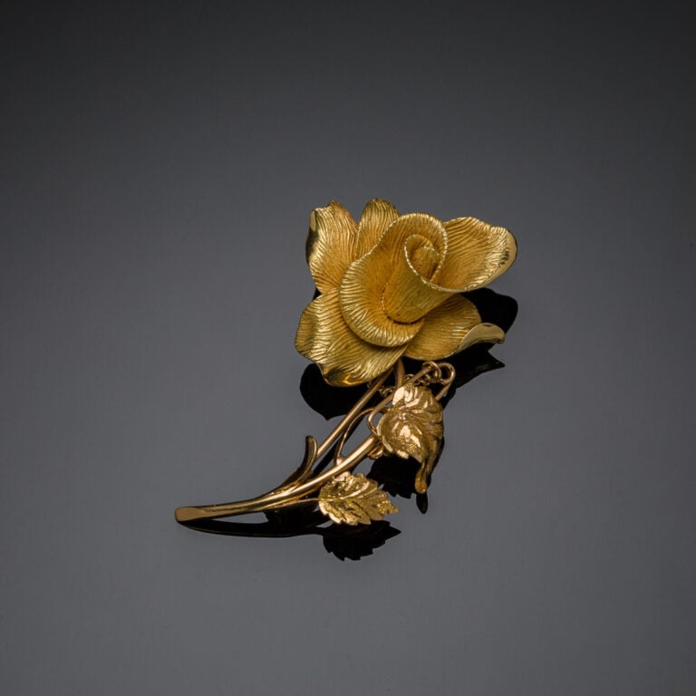 BROCHE "rose" en or jaune (750‰) ciselé et guilloché. Chaînette et épingle de s…