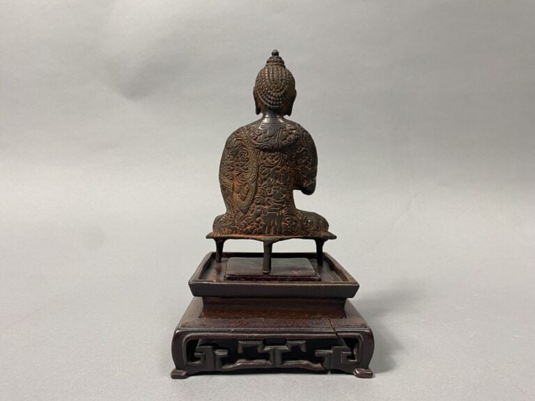 Chine - Bouddha en bronze polychrome représenté assis la main droite levée, en…