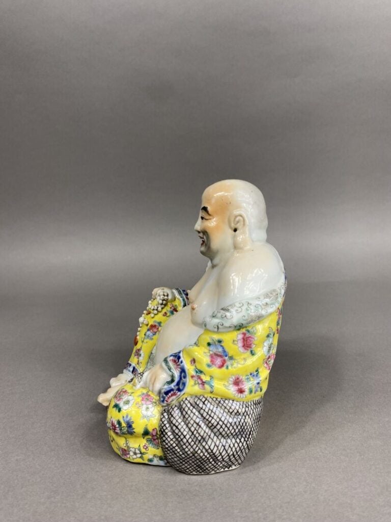 Chine - Bouddha rieur en porcelaine émaillée polychrome représenté assis tenant…