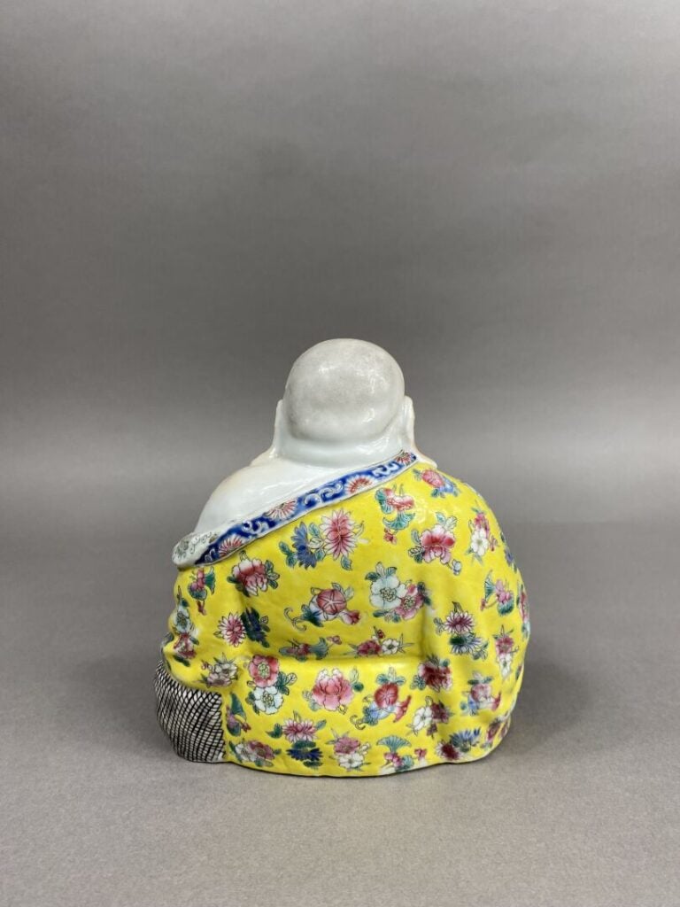Chine - Bouddha rieur en porcelaine émaillée polychrome représenté assis tenant…