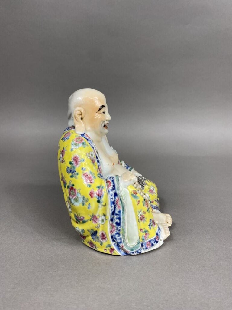 Chine - Bouddha rieur en porcelaine émaillée polychrome représenté assis tenant…