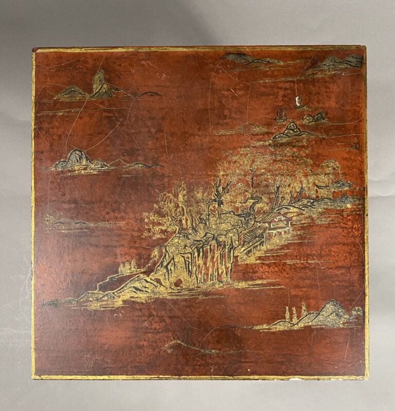 Chine - Petite table basse en bois laqué rouge à décor doré d'un village entour…