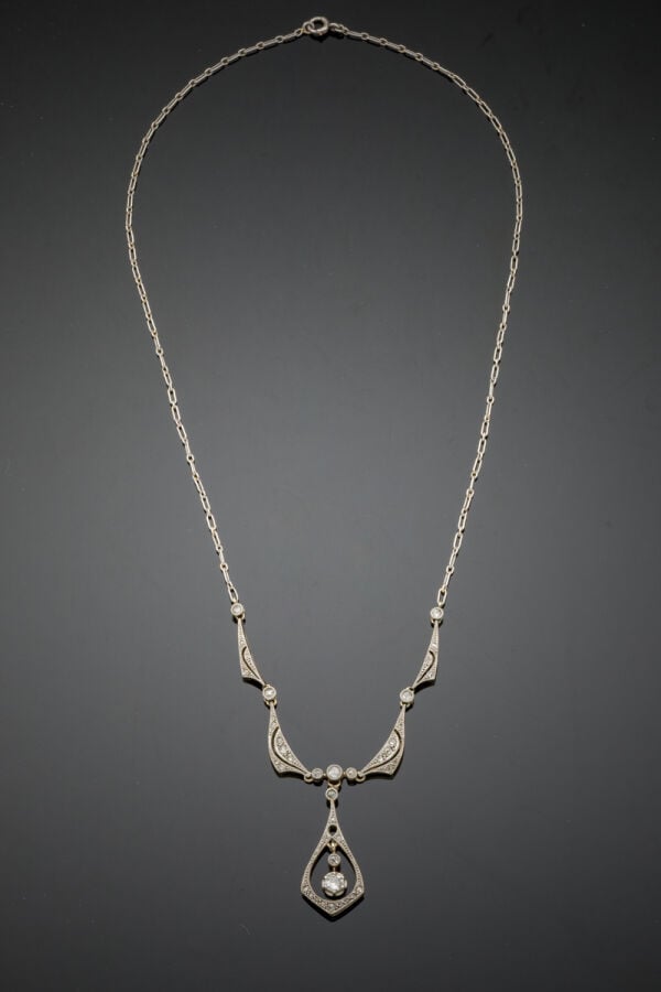 COLLIER en platine (min. 800‰) et or gris (750‰) centré de motifs volute et gou…