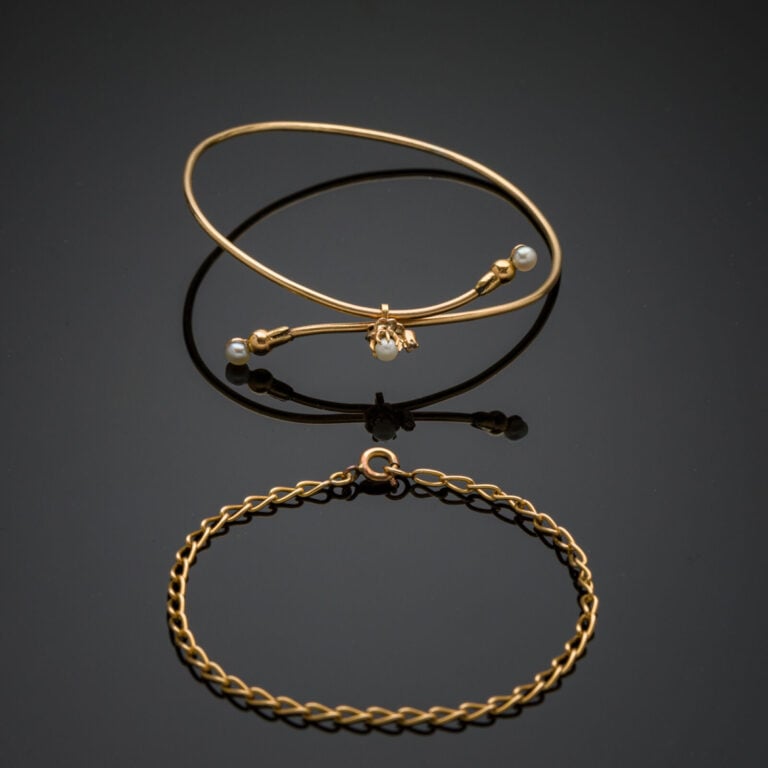 Deux BRACELETS en or jaune (750‰): l'un rigide orné de trois demi-perles, l'aut…