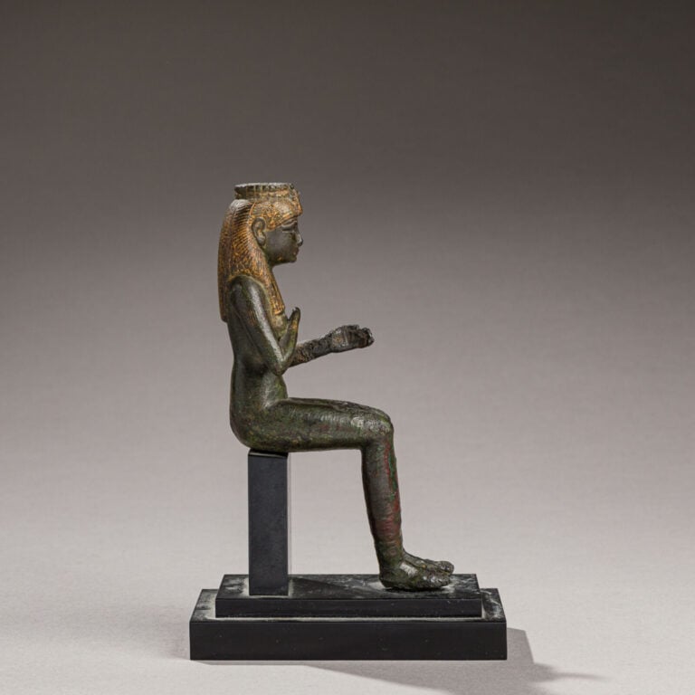 STATUETTE D'ISIS LACTANS, assise, la main droite tenant son sein. Elle retenait…