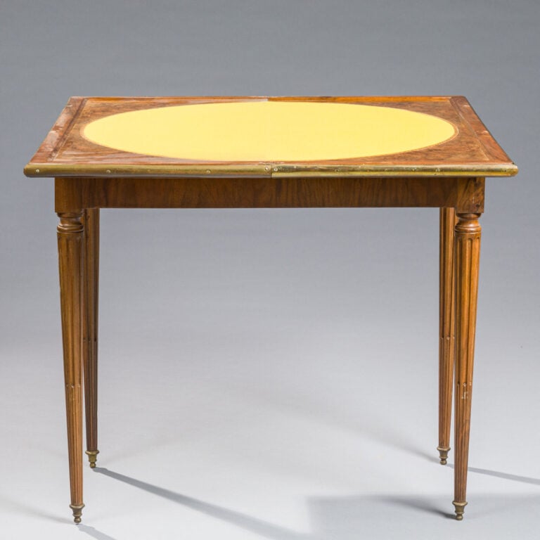 TABLE A JEUX en acajou et placage d'acajou reposant sur quatre pieds cannelés ;…