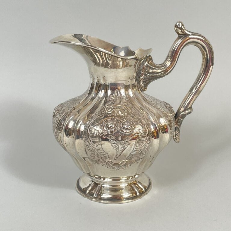 Un POT en argent 915‰ sur piedouche, la panse à décor de boutons de roses - dan…