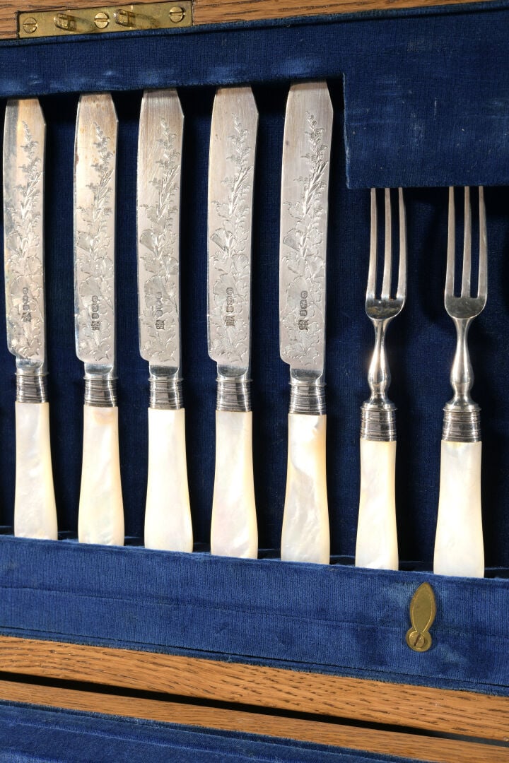 Ménagère comprenant 12 couverts à fruits, fourchettes et couteaux, les manches…
