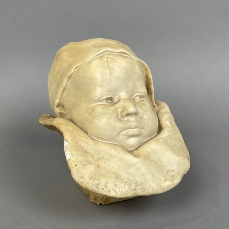 TETE DE BEBE en plâtre patiné (fentes, manques) - Hauteur : 16 cm - Provient de…