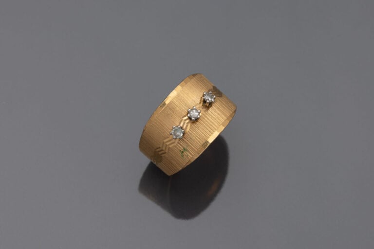 Bague bandeau en or jaune (750) à décor guilloché sertie de trois petits diaman…