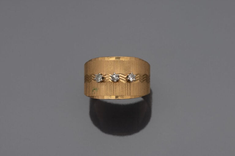 Bague bandeau en or jaune (750) à décor guilloché sertie de trois petits diaman…