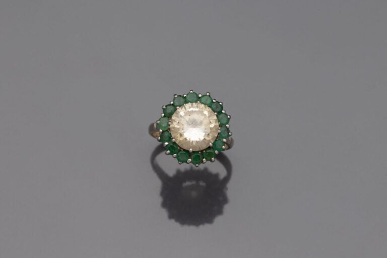 BAGUE circulaire " marguerite " en or gris (750) centrée d'une pierre blanche d…