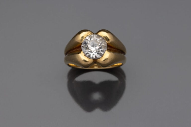 Bague en or jaune (750) à motif godronné centrée d'une pierre blanche facettée…