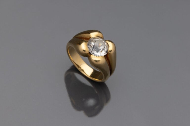 Bague en or jaune (750) à motif godronné centrée d'une pierre blanche facettée…