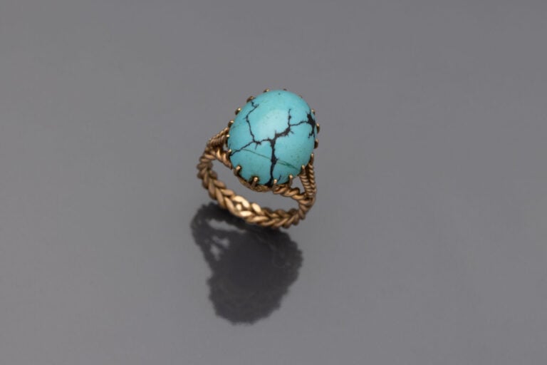 BAGUE en or jaune (750) ajouré, torsadé, et le corps tressé, surmontée d'un cab…