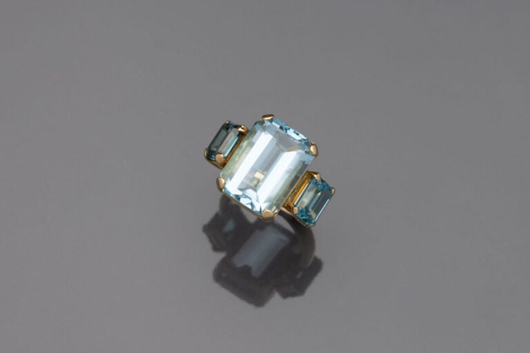 BAGUE en or jaune (750) sertie d'une topaze bleue épaulée de deux zircons bleus…