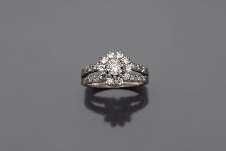 BAGUE " fleur" en or gris (750) ajouré, serti de diamants taille brillant. Sert…