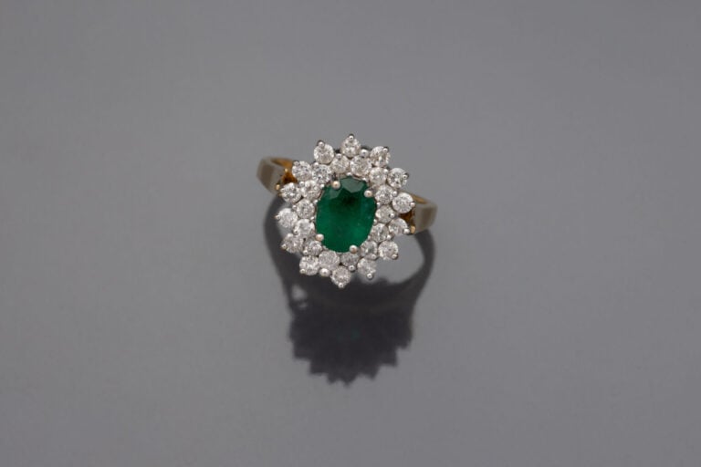 BAGUE "marguerite" en or jaune (750‰) serti d'une émeraude de forme ovale dans…