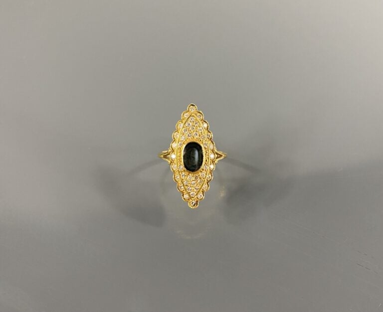 Bague navette en or jaune (750) ornée d'un saphir foncé de taille ovale dans un…