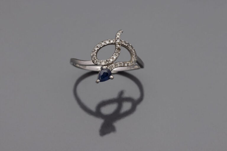 Bague Serpent en or gris (375), la tête ornée d'un petit saphir foncé de taille…