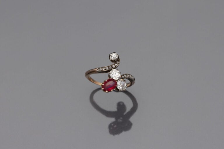 BAGUE " volute " en or jaune (750) et argent (800) serti de trois diamants tail…