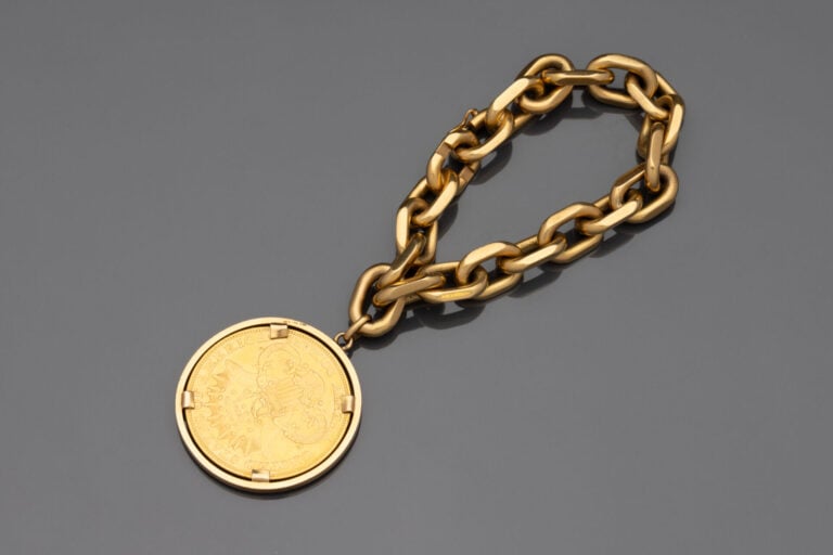 Bracelet gourmette à maille forçat limée retenant une pièce de 20 dollars 1904…