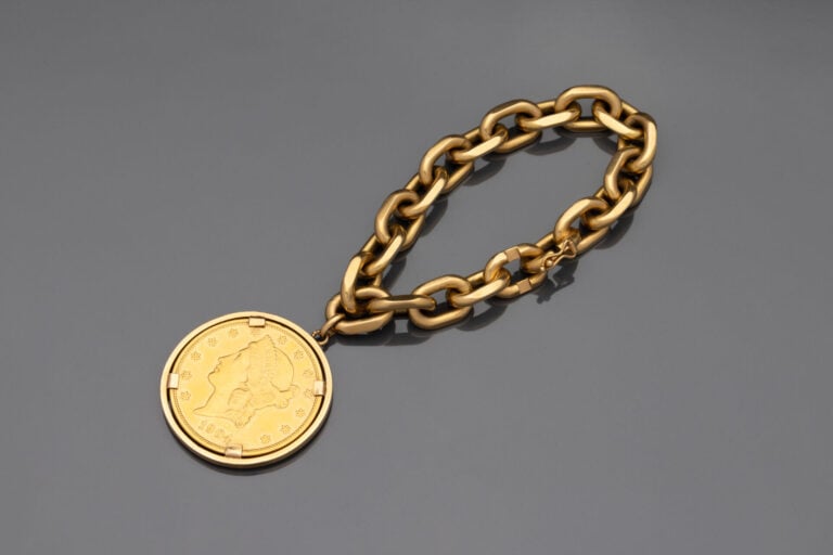 Bracelet gourmette à maille forçat limée retenant une pièce de 20 dollars 1904…