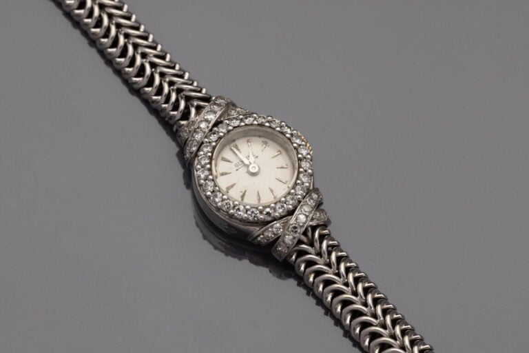 BRACELET MONTRE ronde de dame en or gris (750). Lunette et attaches " croisillo…