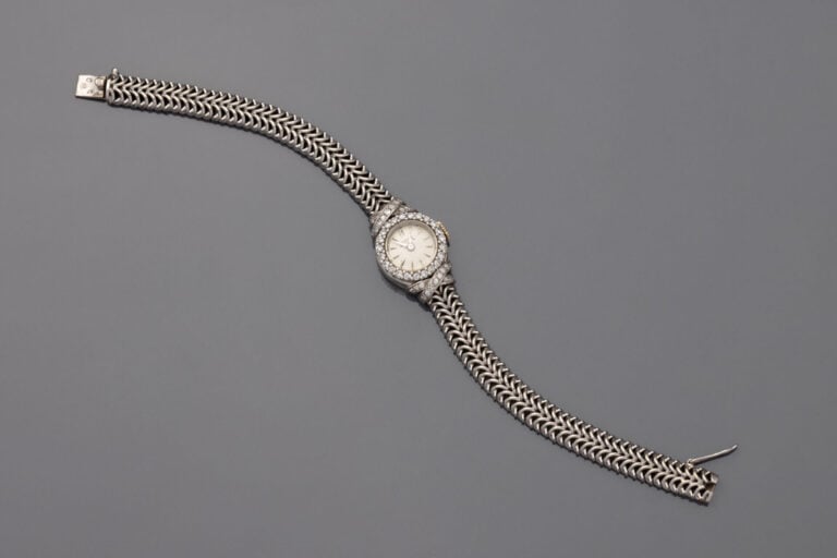 BRACELET MONTRE ronde de dame en or gris (750). Lunette et attaches " croisillo…
