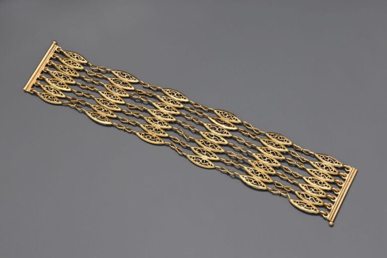 Bracelet ruban articulé en or jaune (750) formé de sept rangs de maille filigra…
