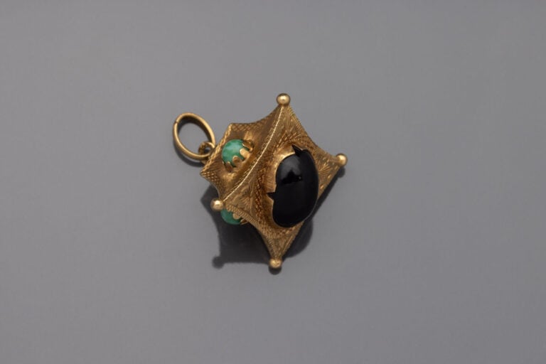 BRELOQUE en or jaune (750) ciselé et guilloché serti de cinq cabochons de pierr…