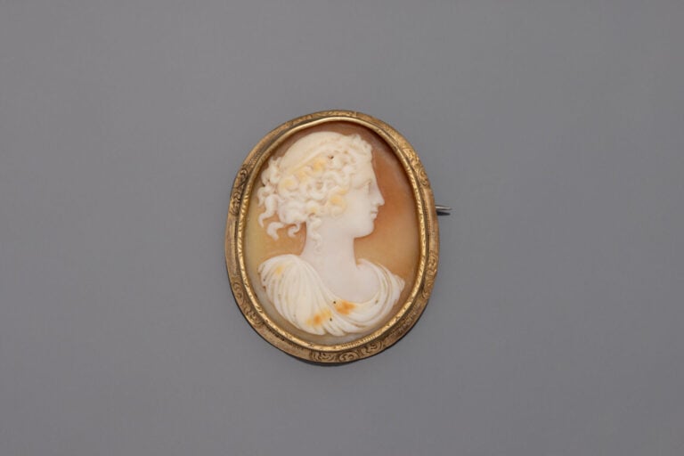 BROCHE ovale en or jaune (375) ciselé ornée d'un camée coquille figurant un pro…