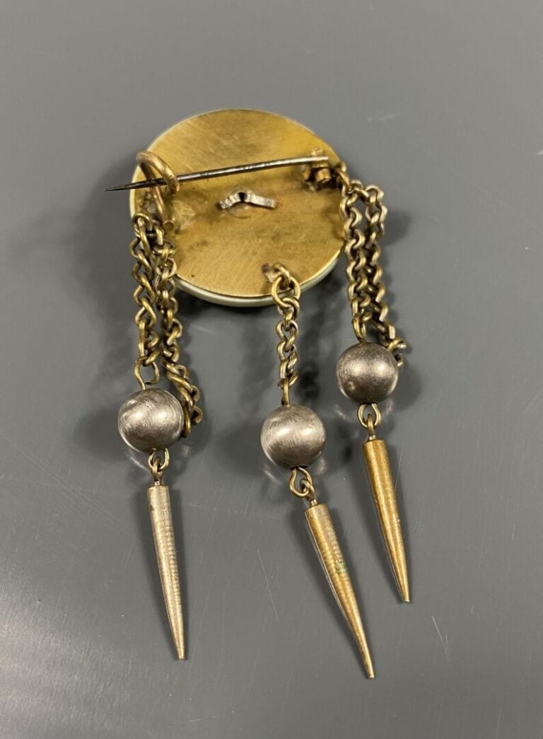 Broche ronde en nacre figurant un profil de femme à l'antique retenant des pamp…