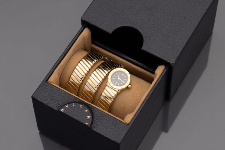 BULGARI - Bracelet montre "Tubogas" ronde de dame trois ors (750). Cadran noir,…