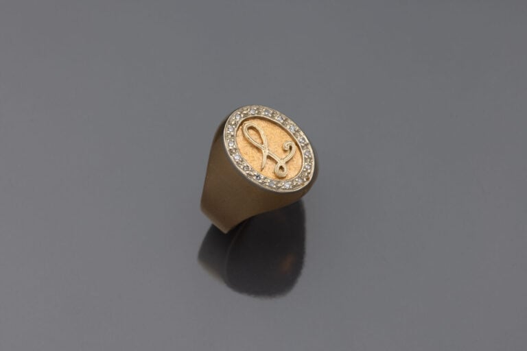 Chevalière en or jaune (750) chiffrée "L", entourage de diamants taille huit-hu…