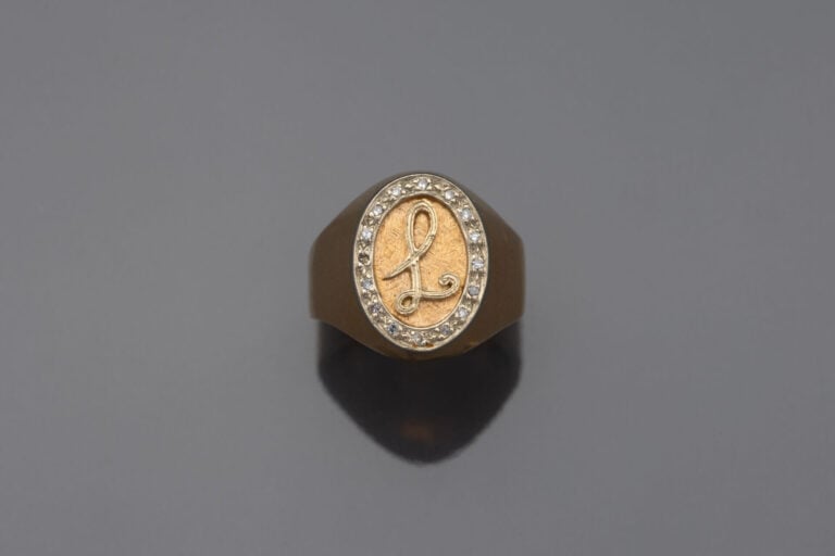 Chevalière en or jaune (750) chiffrée "L", entourage de diamants taille huit-hu…