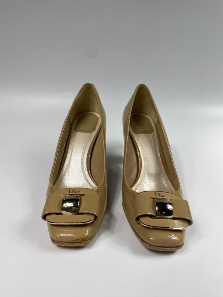 CHRISTIAN DIOR - Escarpins en cuir verni beige, orné d'une plaque en métal doré…
